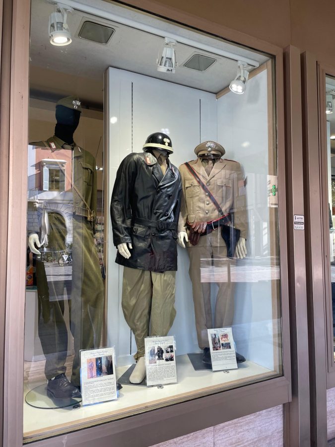 Vetrina che espone uniformi storiche e operative dei Carabinieri, con manichini che indossano diversi abiti, accompagnati da pannelli informativi.