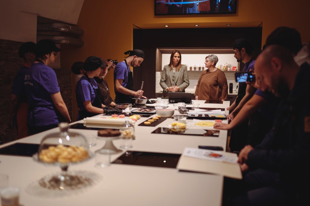 Presentazione dei prodotti da forno della Brigata Indipendente in un laboratorio di pasticceria, con giovani lavoratori e ospiti durante un evento al LAB - Luisa Annibale Base.