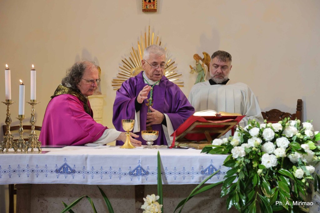 Three priests performing a religious ceremony at an altar decorated with flowers and candles.
