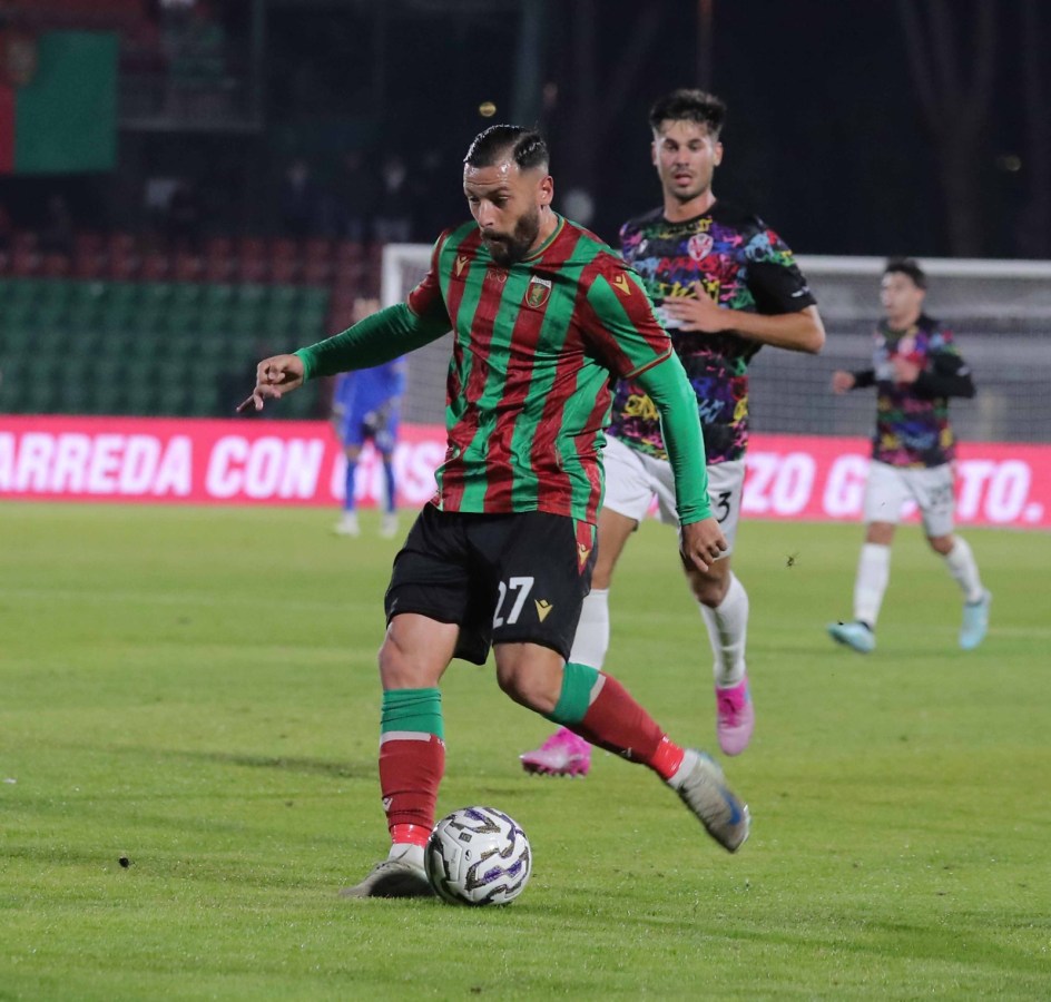 Giocatore della Ternana in azione durante una partita, indossa una maglietta con strisce verdi e rosse.