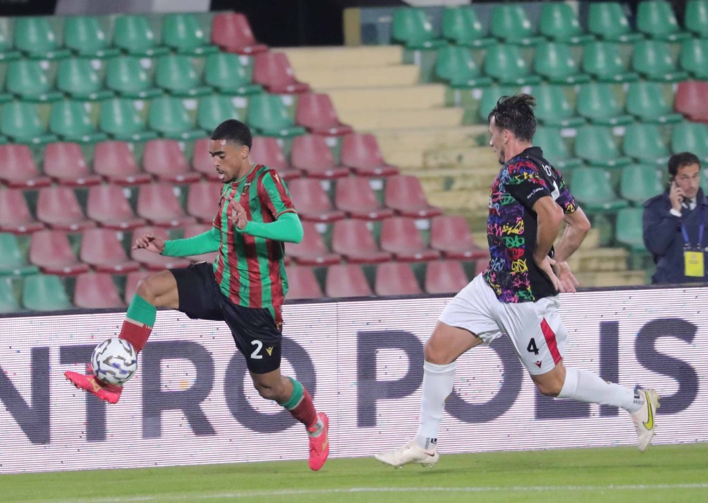 Un giocatore della Ternana in azione con la palla, mentre un avversario della Vis Pesaro lo sfida durante una partita di calcio allo stadio Libero Liberati di Terni.