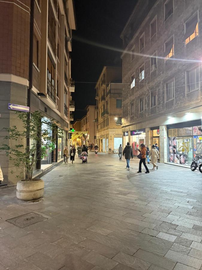 A nighttime street scene with pedestrians, shops on both sides, and illuminated storefronts.
