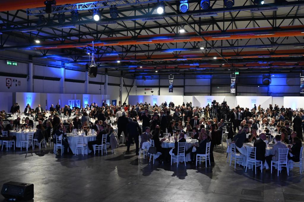 Vista della sala affollata durante la cena di gala per l'Assemblea pubblica di Confindustria Umbria 2025, con tavoli apparecchiati e partecipanti che interagiscono.