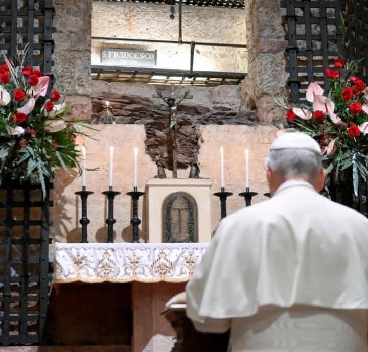 Il Papa si trova in preghiera davanti alla tomba di San Francesco, circondato da candele e fiori.