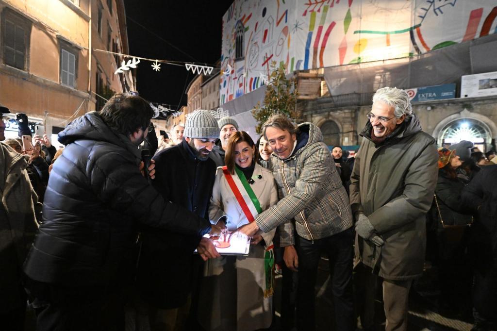 Cerimonia di accensione delle luminarie natalizie a Perugia, con la sindaca Vittoria Ferdinandi e altri ufficiali mentre attivano le luci.