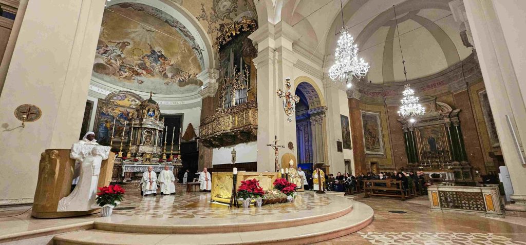 Vista della cattedrale di Terni durante la santa messa della Notte di Natale, con il vescovo Francesco Antonio Soddu e i concelebranti in abiti liturgici, decorazioni natalizie e un'atmosfera festiva.