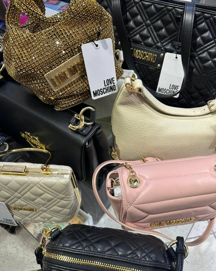 Vari modelli di borse firmate LOVE MOSCHINO in esposizione, inclusi colori metallici e classici.