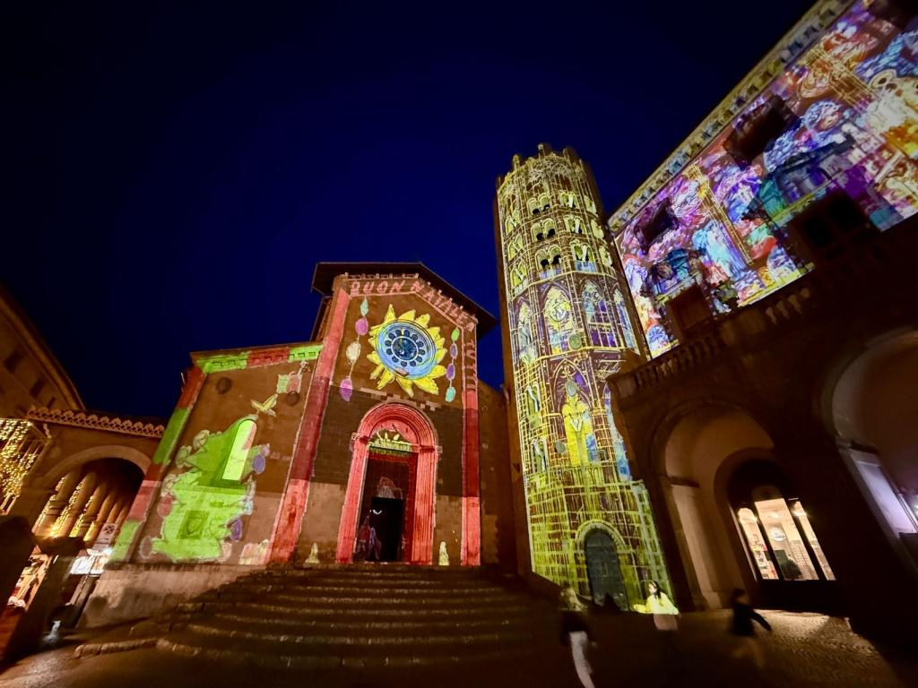 Illuminated historical buildings in Orvieto featuring vibrant holiday-themed projections.