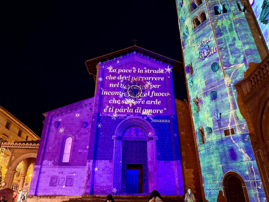 Illuminazione della facciata della chiesa di Sant'Andrea a Orvieto con un messaggio di pace proiettato insieme a decorazioni natalizie, visibile anche il Palazzo comunale.