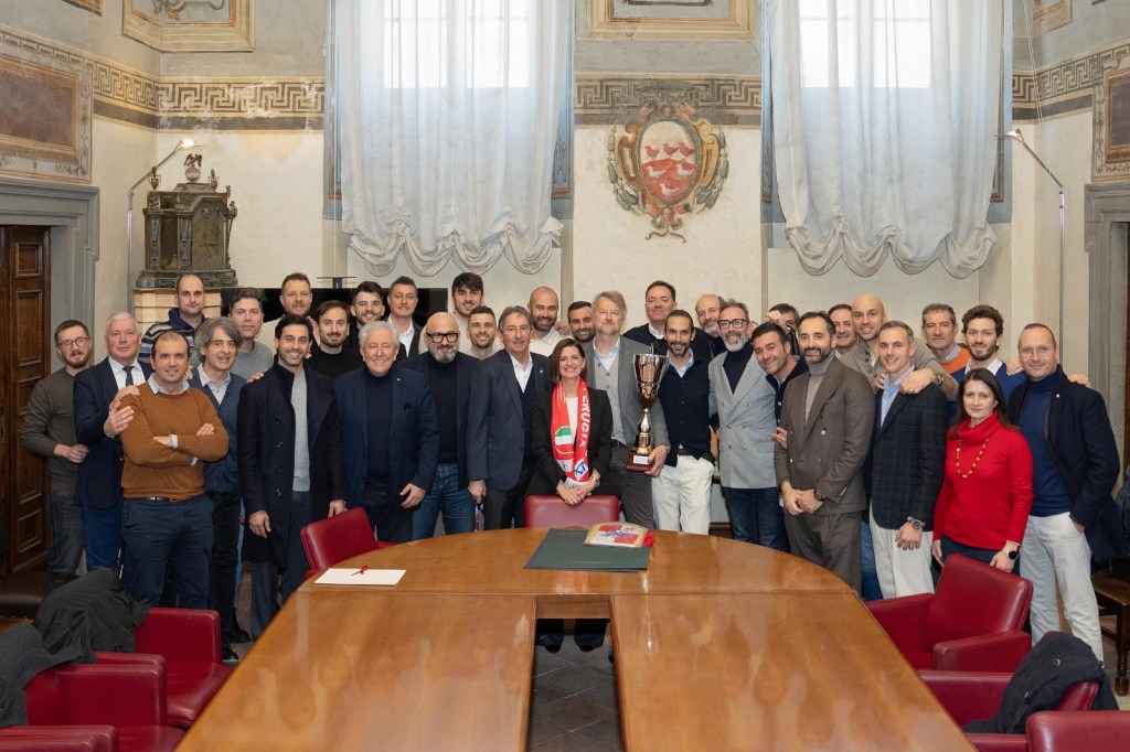 Riunione celebrativa della squadra di calcio a 11 dell'Ordine degli ingegneri di Perugia, con la sindaca Vittoria Ferdinandi e l'assessore allo sport Pierluigi Vossi, in un ambiente elegante, con il trofeo vinto sul tavolo.