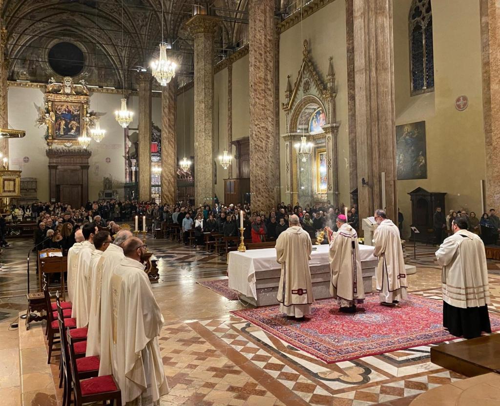 Celebration of Christmas Eve Mass at the Cathedral of San Lorenzo in Perugia, featuring Archbishop Ivan Maffeis and multiple clergy members in religious attire, with a congregation present in the background.
