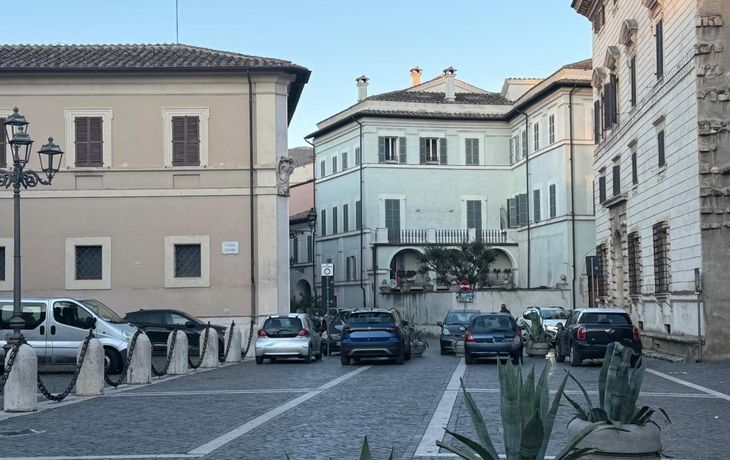 A quiet street scene featuring parked cars and historic buildings, with a mix of modern and traditional architectural elements.