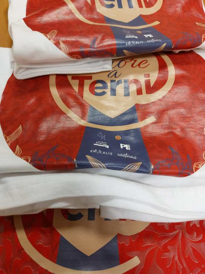 Una maglietta con il design che presenta la scritta 'Amore a Terni' su uno sfondo rosso, con elementi decorativi.