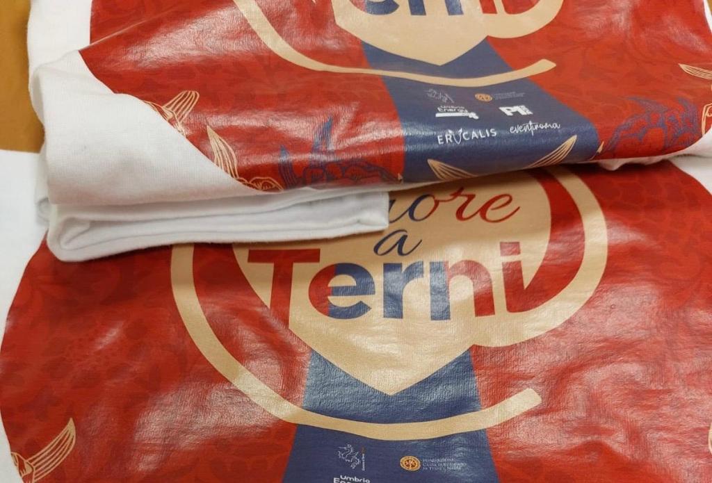 Folded fabric showcasing the phrase 'Amore a Terni' on a red and blue background, with decorative elements.