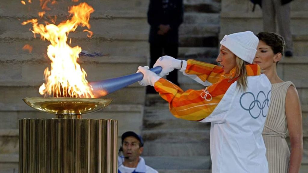 Una tedofora accende il braciere della Fiamma Olimpica durante una cerimonia.