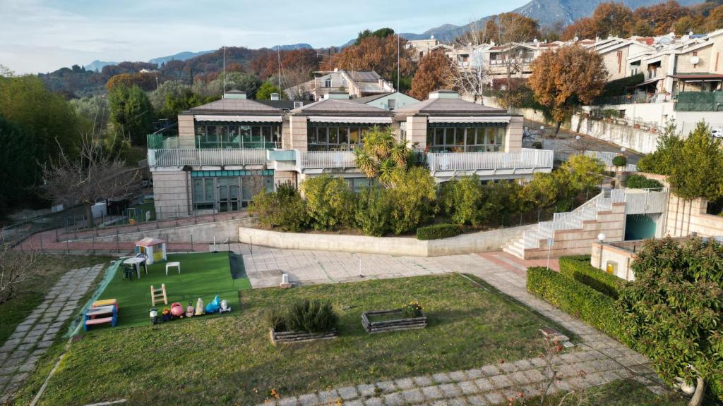 Vista esterna della struttura educativa 'Io, Bambino', circondata da un parco e attrezzata per attività per bambini.