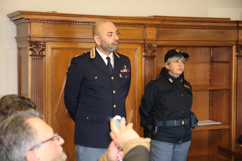 Due funzionari di polizia durante una conferenza stampa presso l'azienda ospedaliera di Terni, con sfondo di arredi in legno.