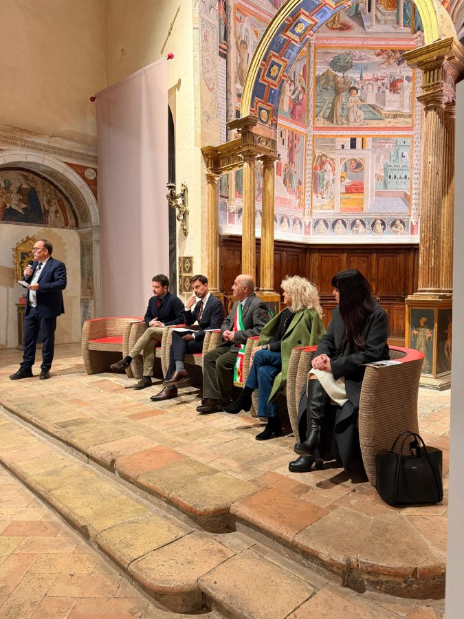 Un momento dell'inaugurazione della mostra 'Steve McCurry – Umbria' al Complesso museale San Francesco, con diversi relatori seduti su poltrone nel contesto architettonico decorato.