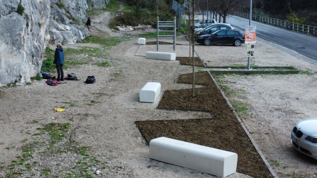 Vista dell'area riqualificata ai piedi dell'Isola di Ferentillo, con nuove alberature, sedute in travertino e attrezzature per l'allenamento sportivo.