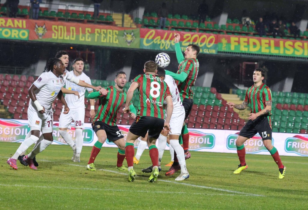 Giocatori della Ternana e del Livorno in un'azione di gioco durante una partita di calcio, sotto la pioggia e con un campo bagnato.