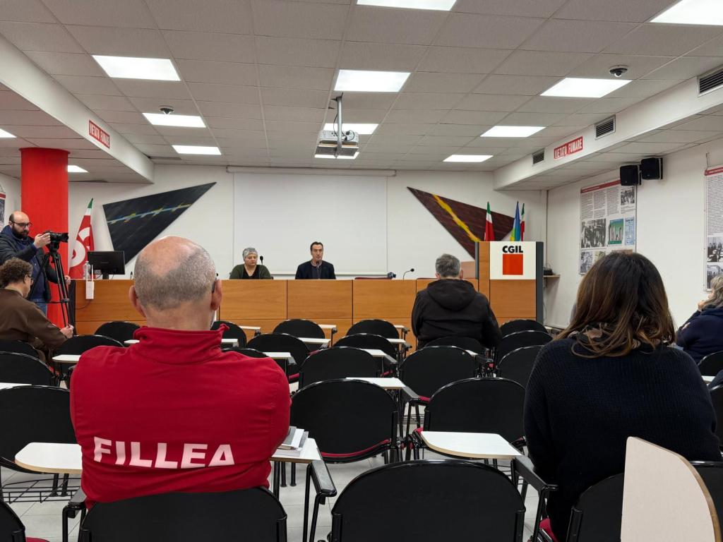 Conferenza stampa della Cgil di Terni, con relatori al tavolo e pubblico seduto, durante la discussione su tematiche socio-economiche.