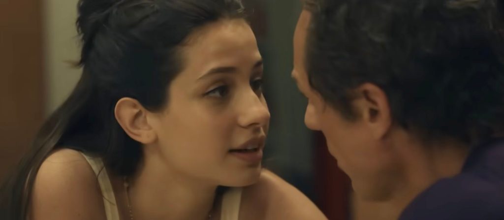 Una scena intima tra due personaggi, con la giovane donna che guarda il suo interlocutore mentre si avvicinano l'uno all'altra.