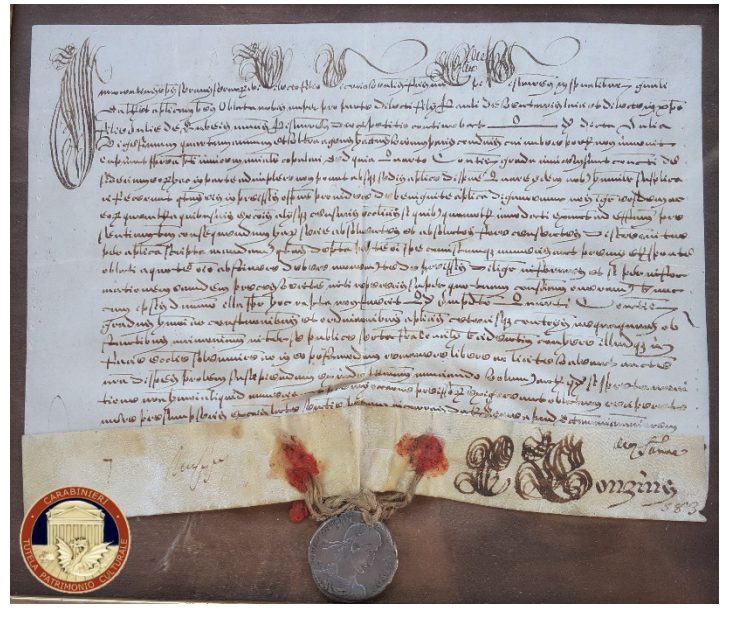 An old handwritten document featuring elegant script, decorative elements at the top, and a wax seal attached with twine and colored cloth remnants.