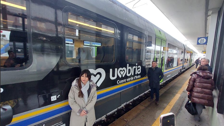 Un nuovo treno Minuetto in sosta alla stazione con persone in attesa, evidenziando il design e la livrea dedicata all'Umbria.