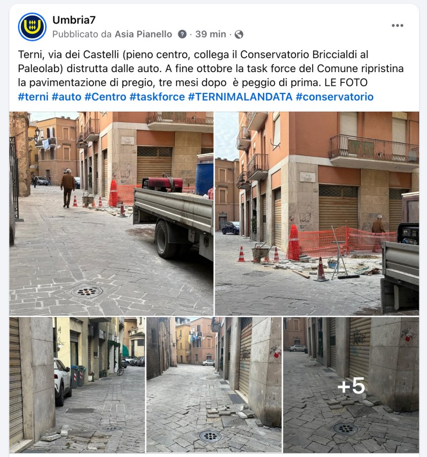 Narrow street in Terni with construction work in progress, showcasing uneven pavement and orange traffic cones.