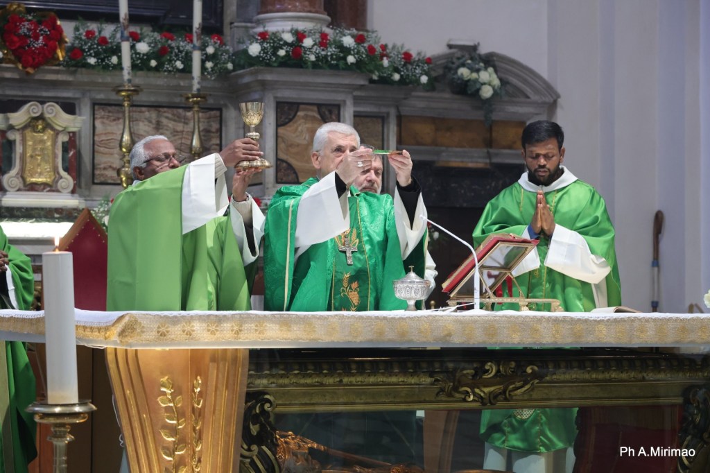 Clergy in green vestments participating in a religious ceremony, holding chalices and gestures of prayer at an altar.