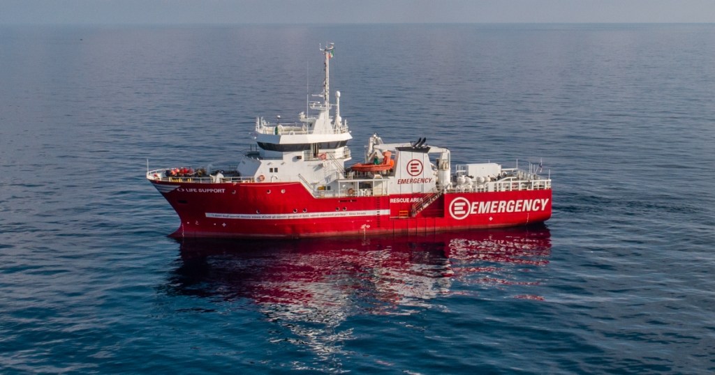 A red emergency response ship labeled 'LIFE SUPPORT' and 'EMERGENCY' navigating in calm ocean waters.