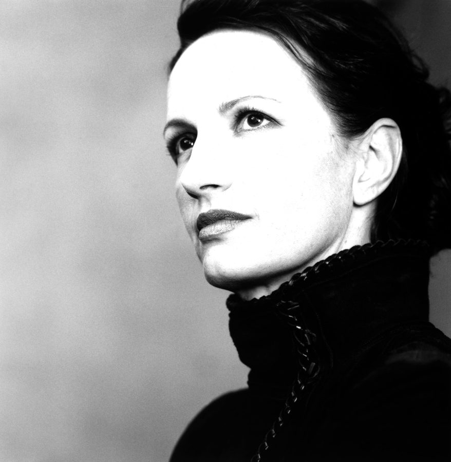 Black and white portrait of a woman with a confident expression, wearing a high-collared garment.